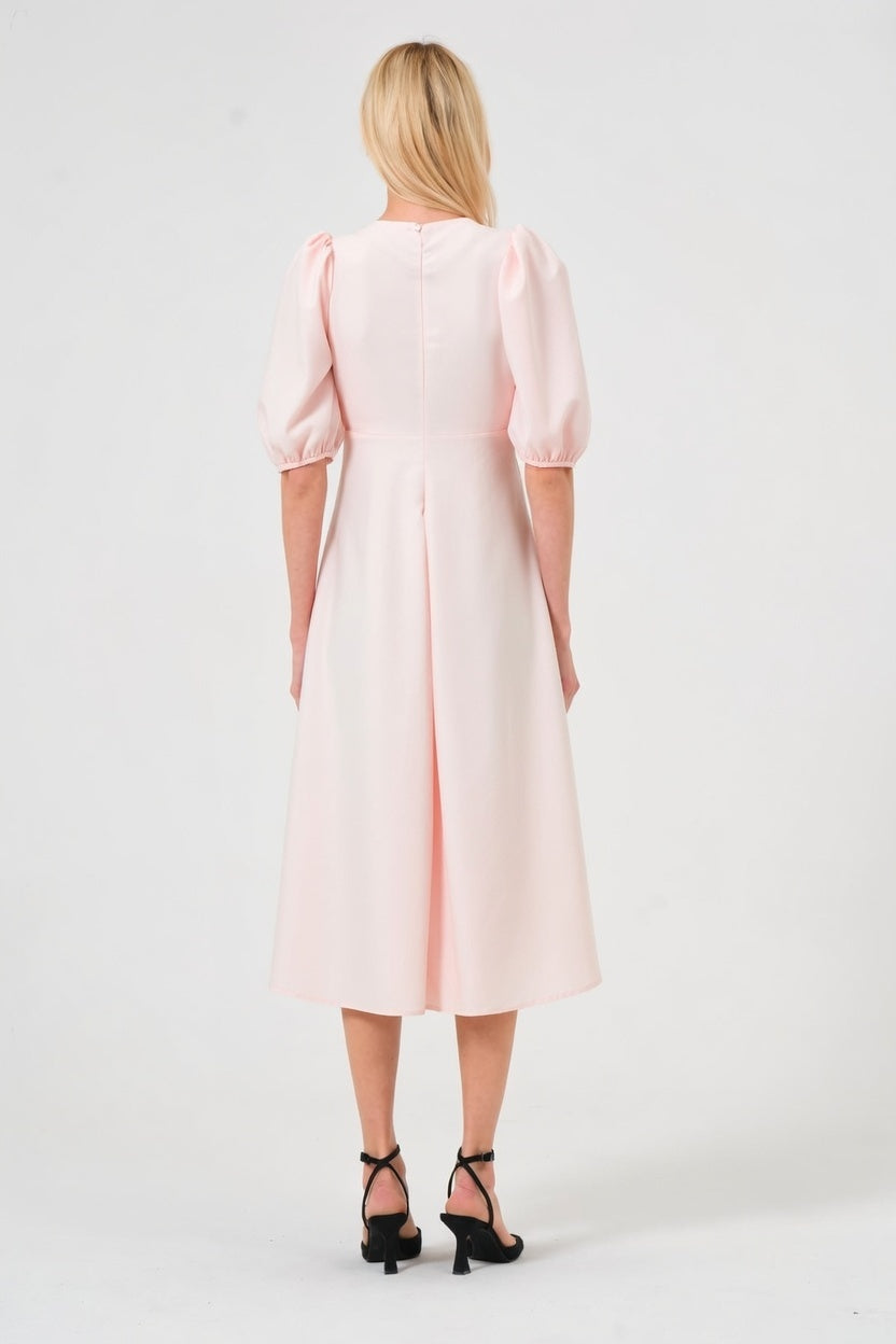 Woman wearing a light pink dress on a white background