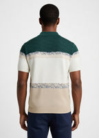 Man wearing a green and beige striped polo shirt with floral patterns on a white background