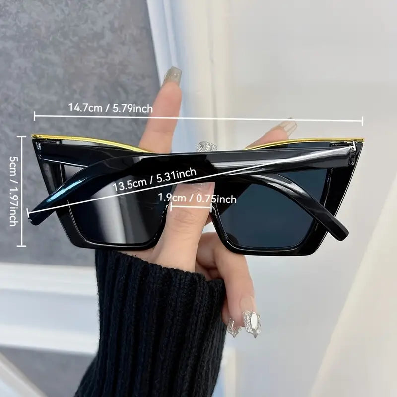 Black sunglasses held by a hand with measurements displayed