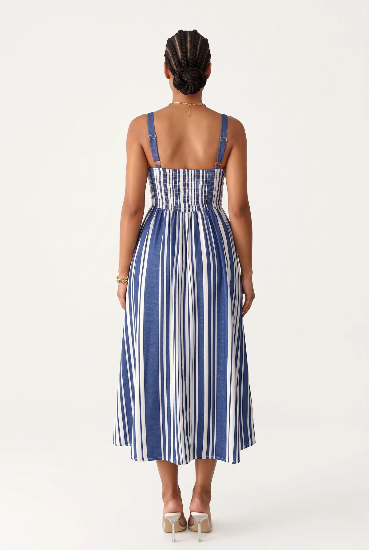 Woman wearing an A-line midi dress features a bold, vertical stripe pattern in alternating royal blue and white that creates a slimming and elongating visual effect. Designed with a structured square neckline, thick supportive straps, and a solid blue upper border, the fitted bodice gracefully transitions into a flared, flowing skirt that falls just below the calves.