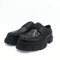 Black leather shoes with thick soles on a white background