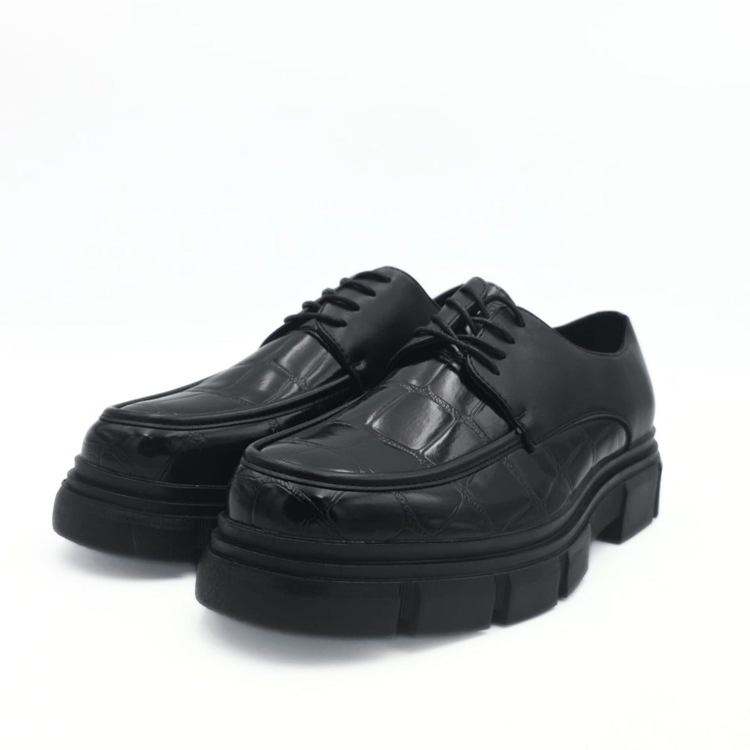 Black leather shoes with thick soles on a white background