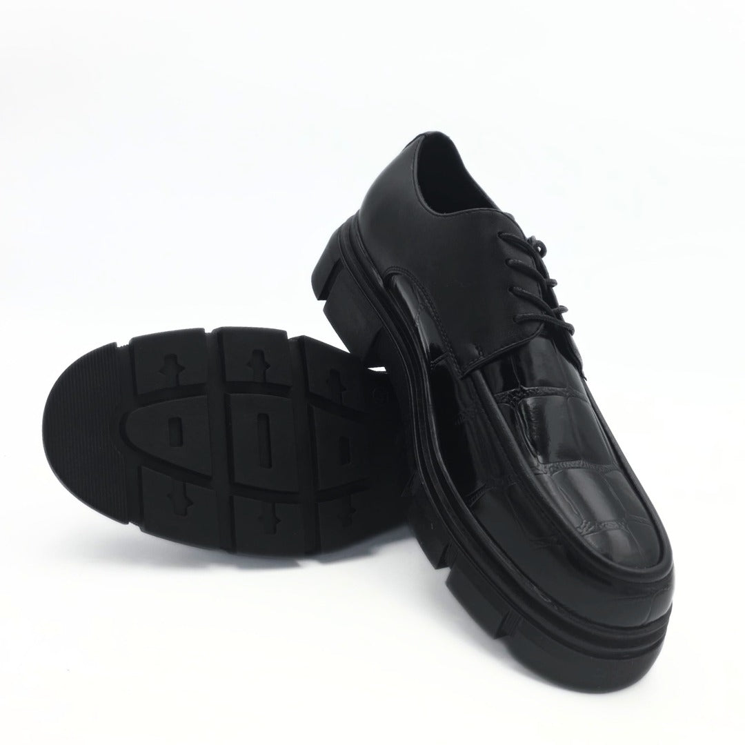 Black shoes with thick soles on a white background