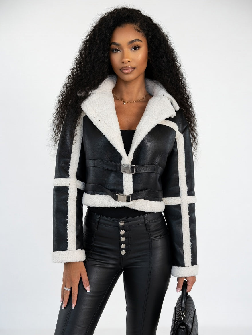 Woman wearing a black leather jacket with white fur trim on a white background