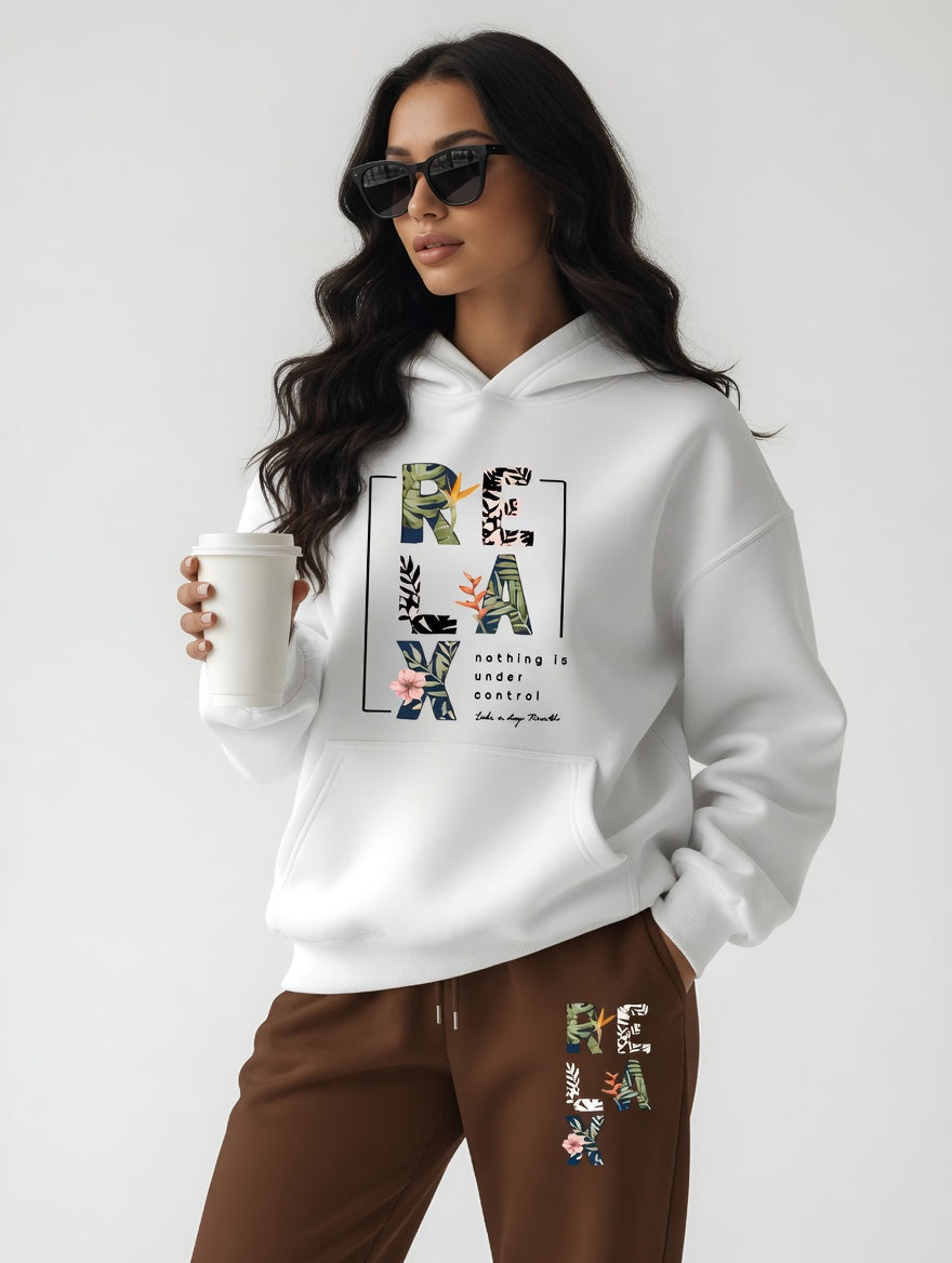 Woman wearing a white hoodie with text and graphics, holding a mug on a plain background