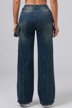 Blue jeans being worn on a plain background