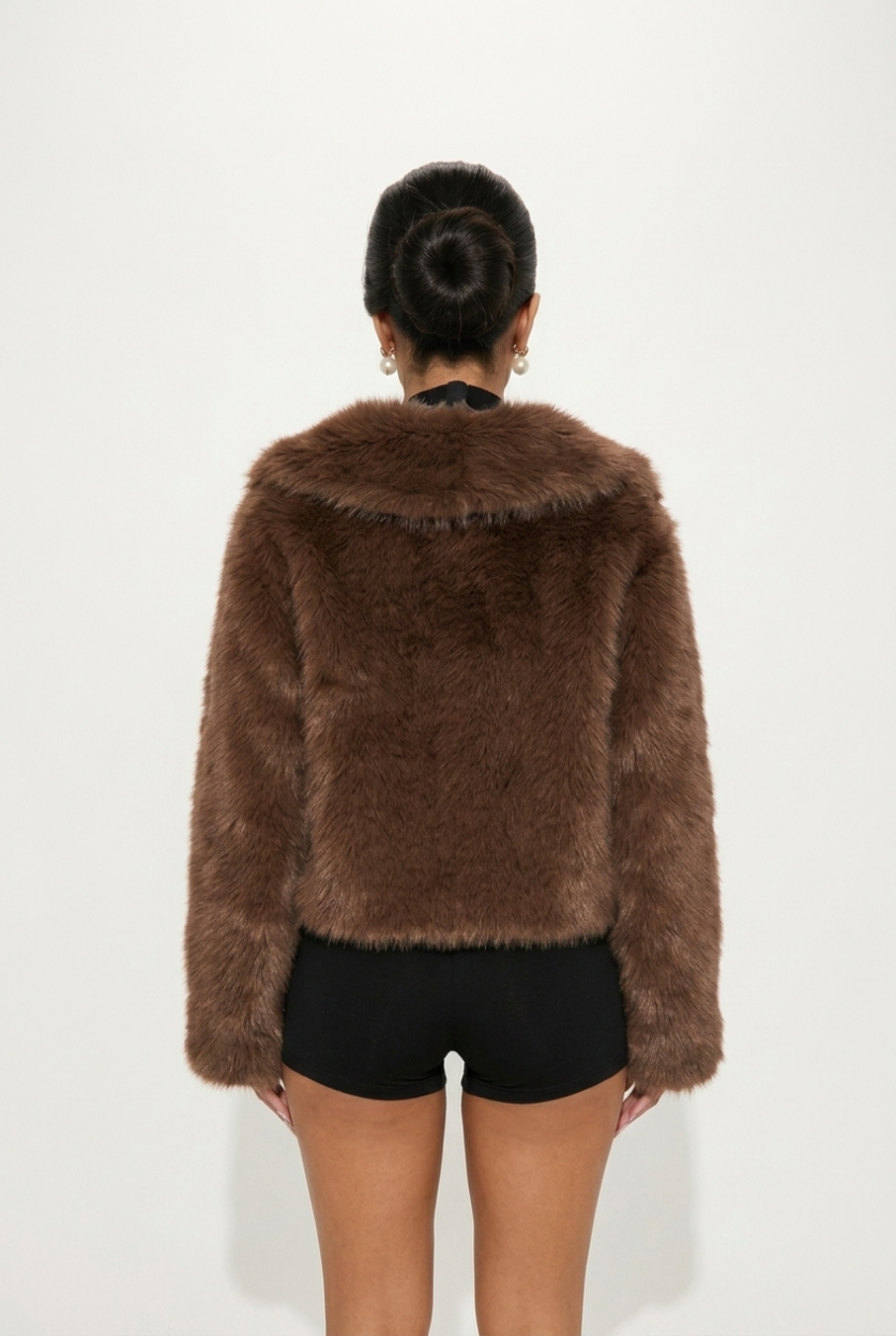Brown fur jacket worn by a person on a white background