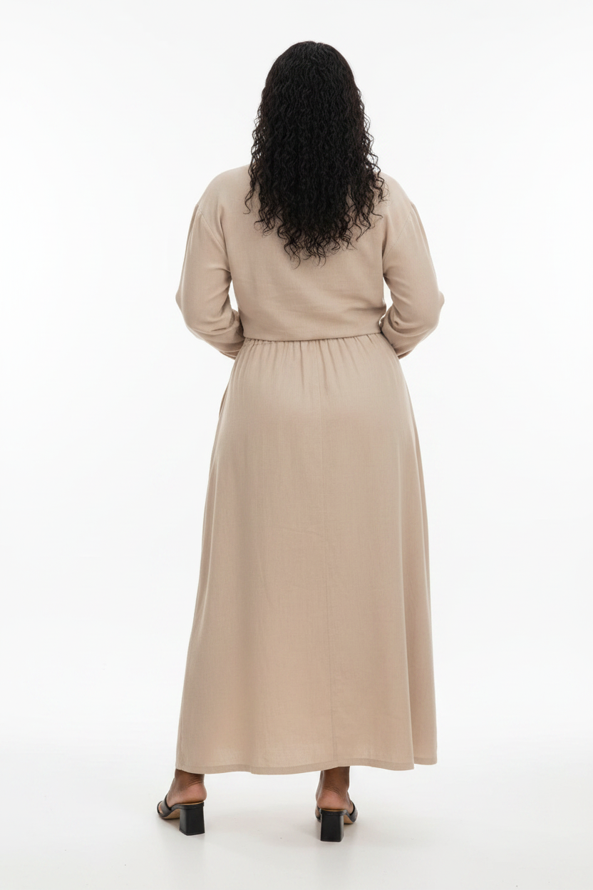 Person wearing a beige dress standing in a whitebackg.ound
