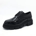 Black leather shoe with thick sole on a white background