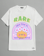 White t-shirt with a colorful graphic design featuring text and a cartoon face on a gray background