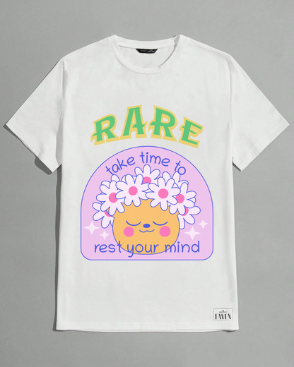 White t-shirt with a colorful graphic design featuring text and a cartoon face on a gray background