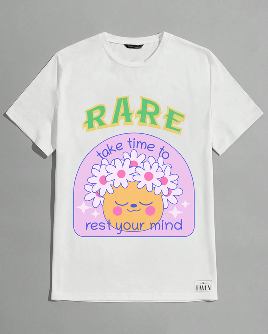 White t-shirt with a colorful graphic design featuring text and a cartoon face on a gray background