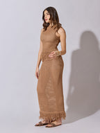Woman wearing a brown crochet dress against a white background
