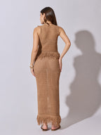 Woman wearing a brown crochet dress against a white background