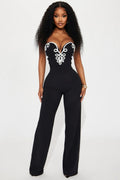 Black jumpsuit with white lace details worn by a model on a white background