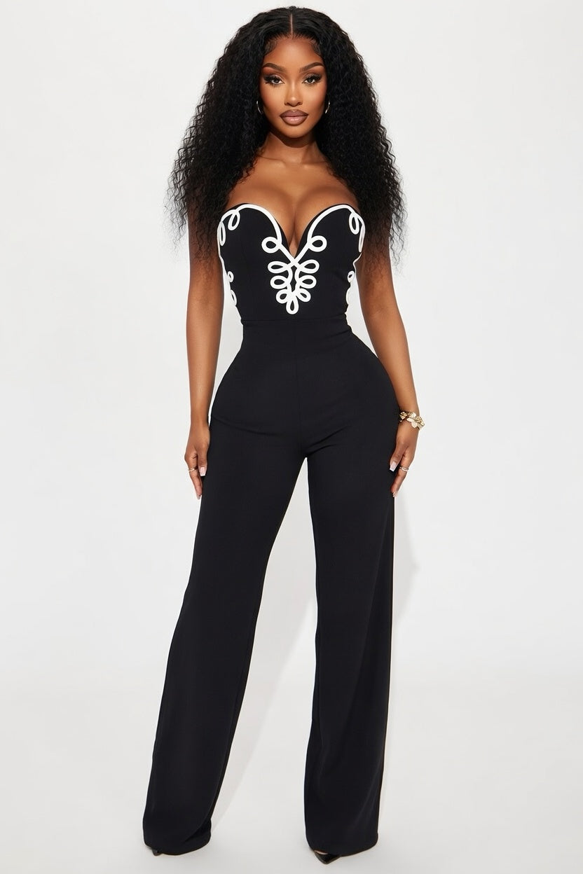 Black jumpsuit with white lace details worn by a model on a white background