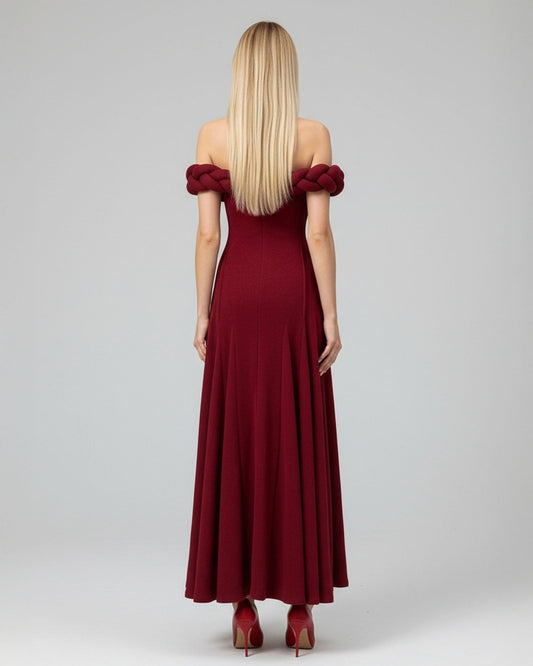 Woman wearing a burgundy off-shoulder dress on a gray background