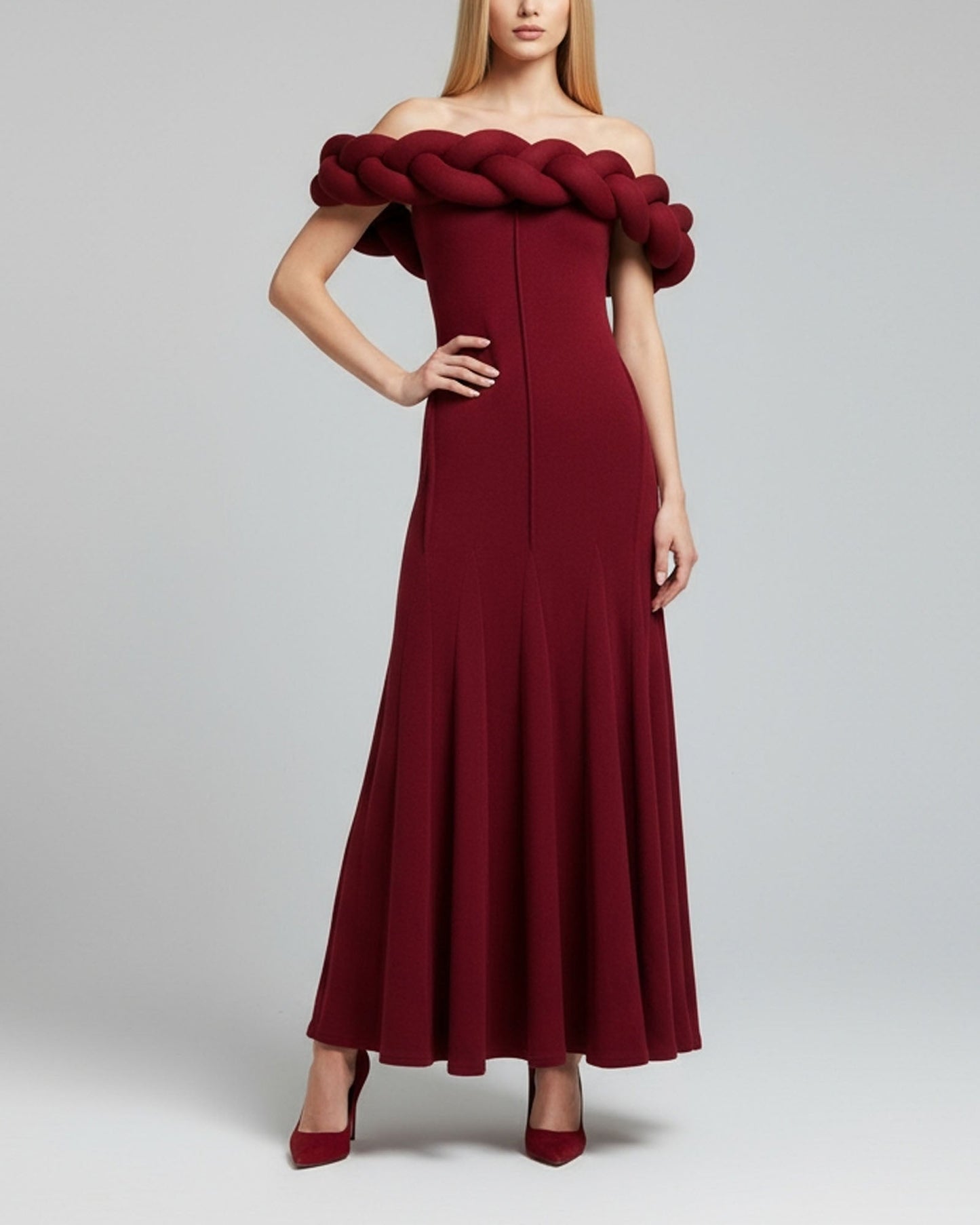 Red off-shoulder dress with braided detail on a plain background