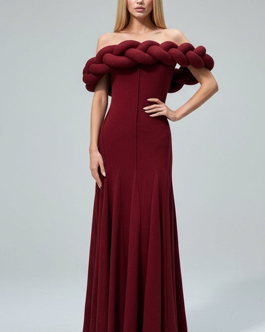 Maroon off-shoulder gown with unique top design on a plain background