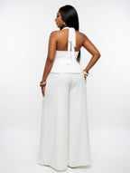 Woman wearing a white jumpsuit on a plain background