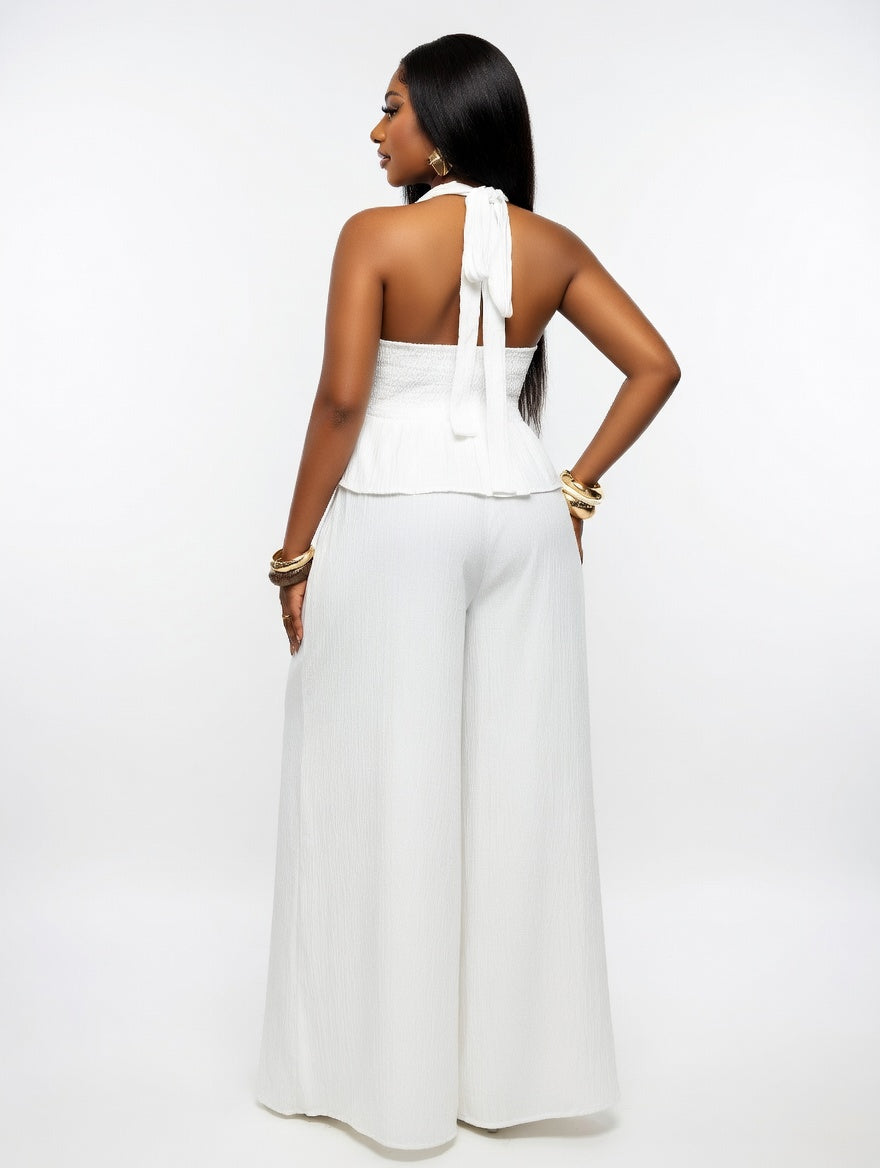 Woman wearing a white jumpsuit on a plain background