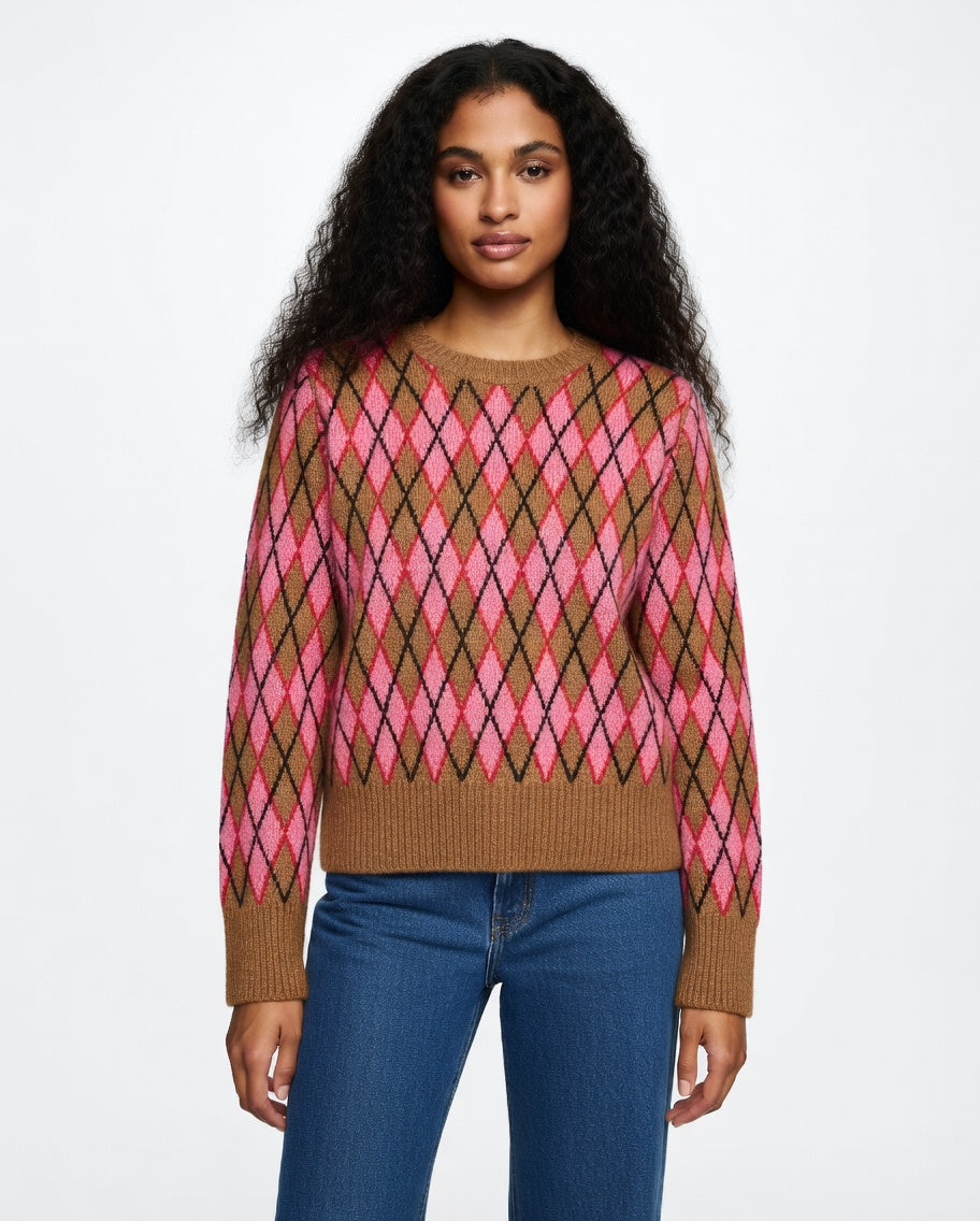 Woman wearing a brown and pink argyle sweater with blue jeans on a white background