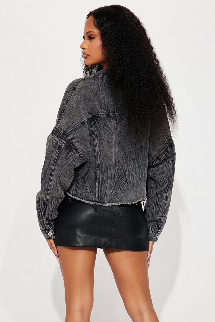 Woman wearing a black denim jacket and black leather skirt on a white background