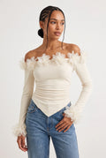 Elegant off-the-shoulder top in a soft cream hue is crafted from a smooth, form-fitting fabric with delicate ruching along the torso that accentuates the silhouette. 