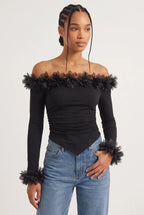 Elegant off-the-shoulder top in a soft black hue is crafted from a smooth, form-fitting fabric with delicate ruching along the torso that accentuates the silhouette. 