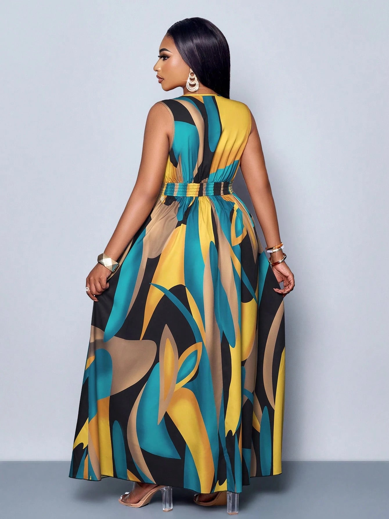 Woman wearing a colorful patterned dress against a plain background
