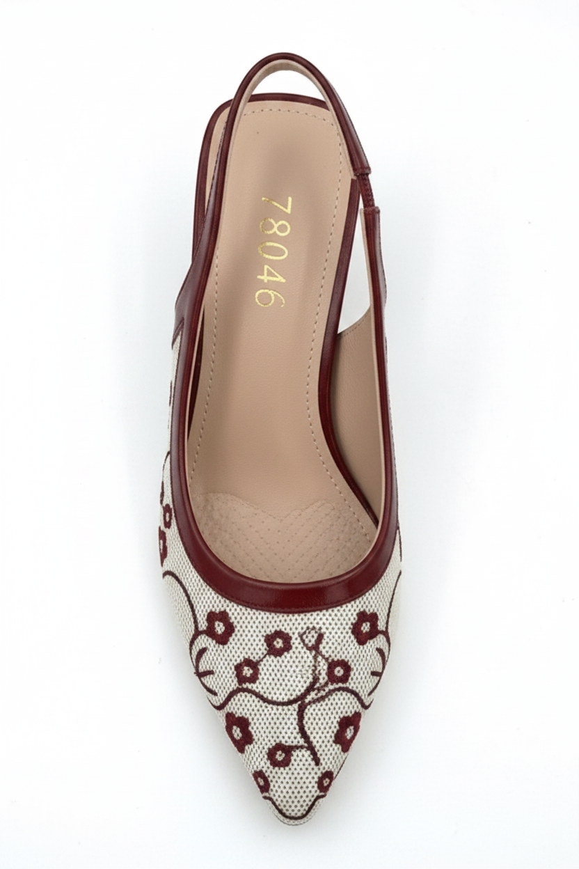 White shoe with floral pattern and maroon heel on a white background