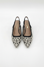 Black and white floral patterned shoes on a light gray background