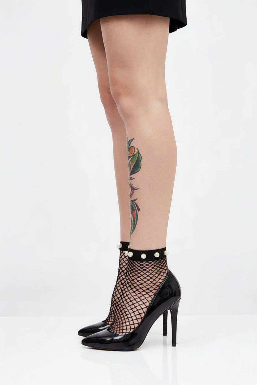 Black fishnet stockings with pearl accents worn by a person on a white background
