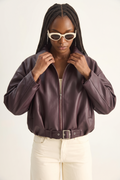 Woman wearing a brown leather jacket and sunglasses on a white background