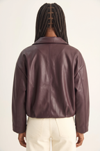 Person wearing a brown leather jacket on a white background