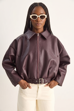 Person wearing a brown leather jacket and sunglasses on a white background