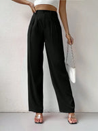 Person wearing black wide-leg pants with a white background