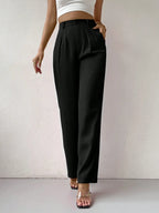 Person wearing black high-waisted pants against a plain background