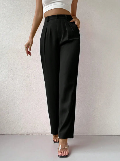 Person wearing black high-waisted pants against a plain background
