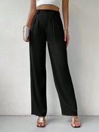 Person wearing black high-waisted pants on a plain background