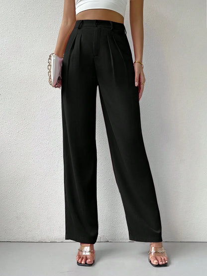 Person wearing black high-waisted pants on a plain background