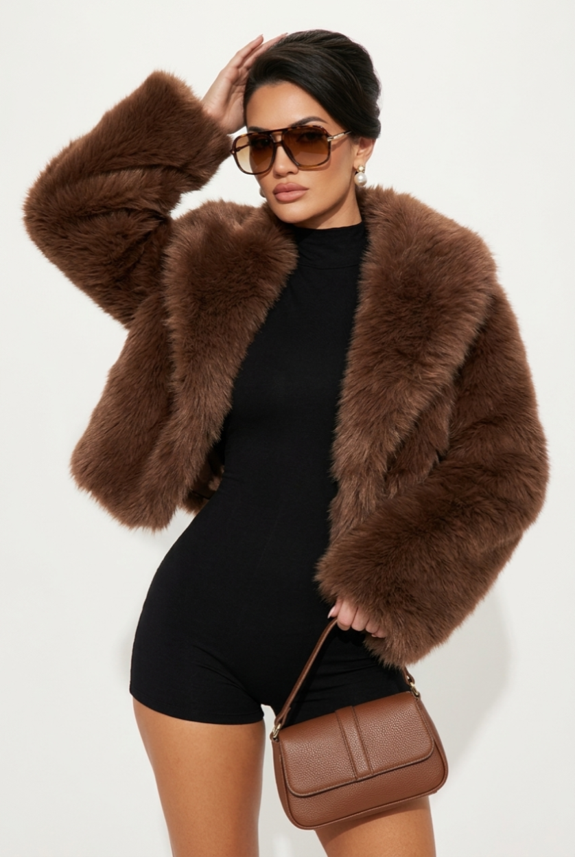 Woman wearing a brown fur coat and sunglasses, holding a matching handbag on a white background