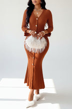 Woman wearing a brown ribbed dress with white fringes indoors.