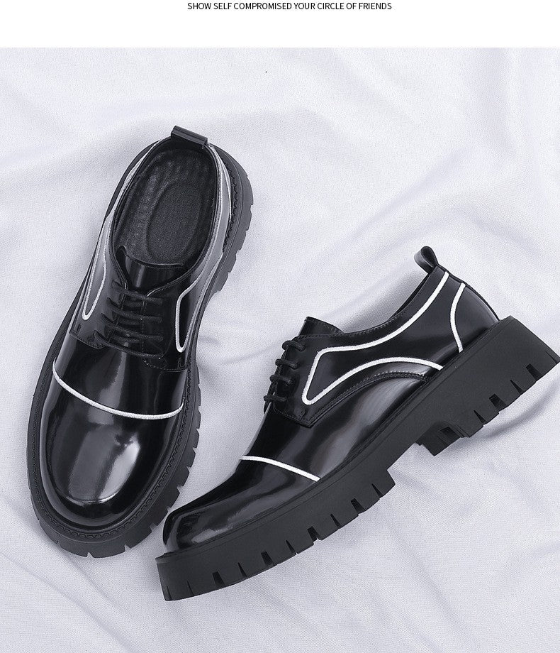 Black platform shoes with white accents on a light gray background