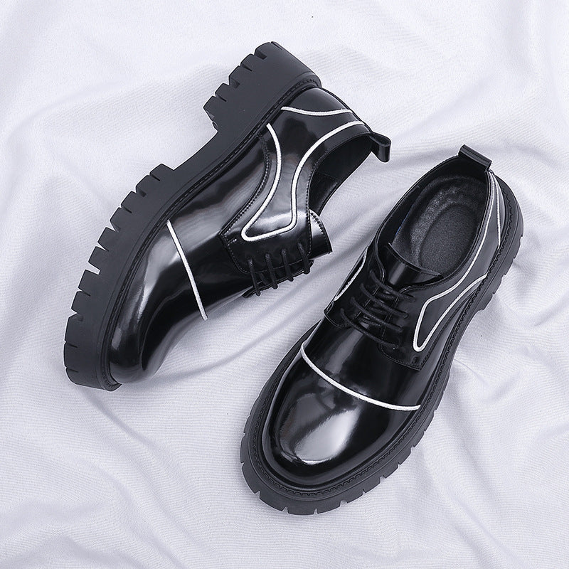 Black glossy shoes with white accents on a white fabric background