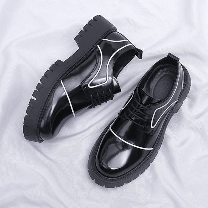 Black glossy shoes with white accents on a white fabric background
