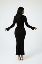 Woman wearing a black ribbed dress on a white background
