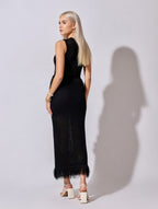 Woman wearing a black dress with feather details on a white background