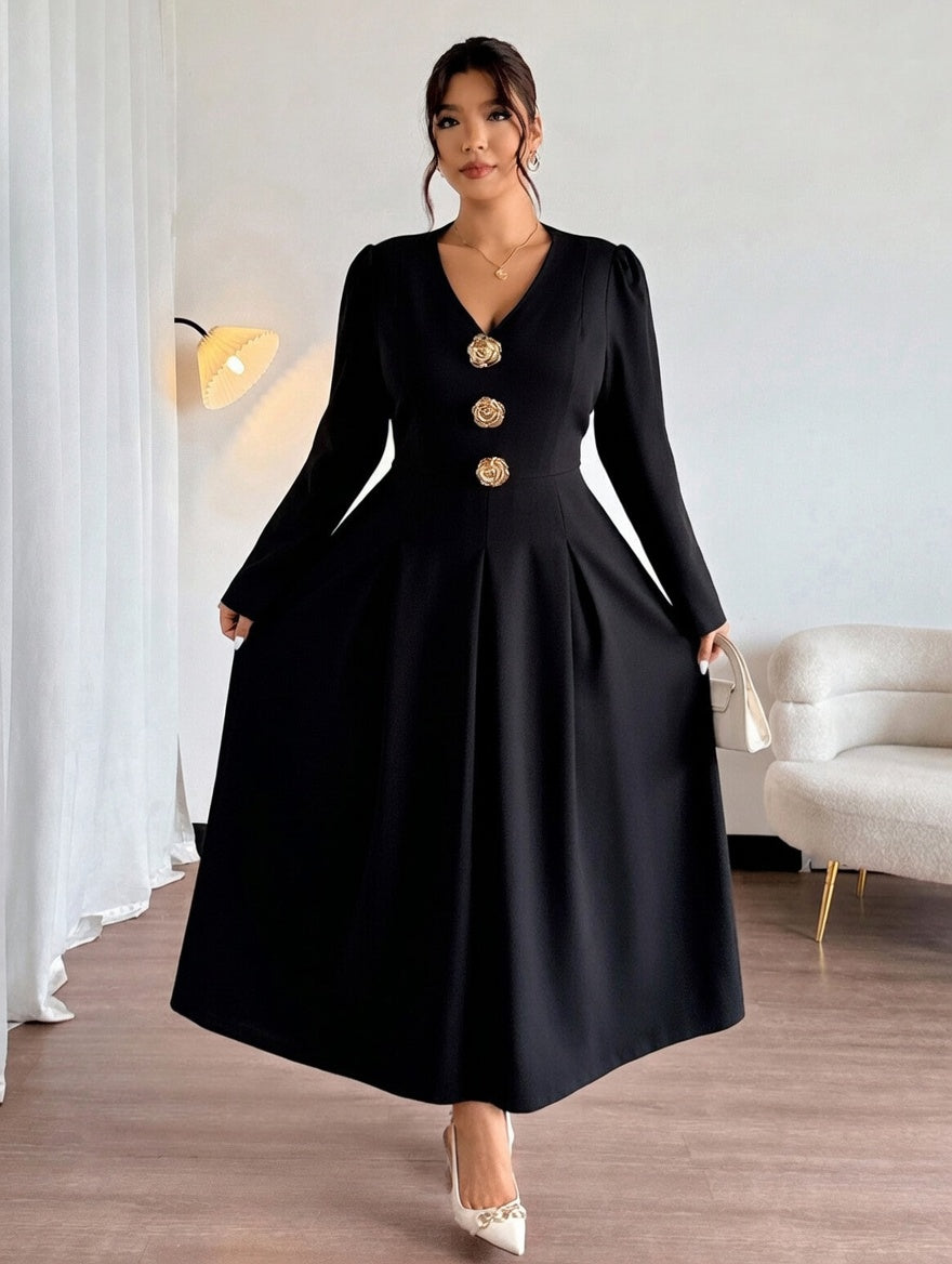 Woman wearing a black dress with gold buttons in a room with a white sofa and lamp.