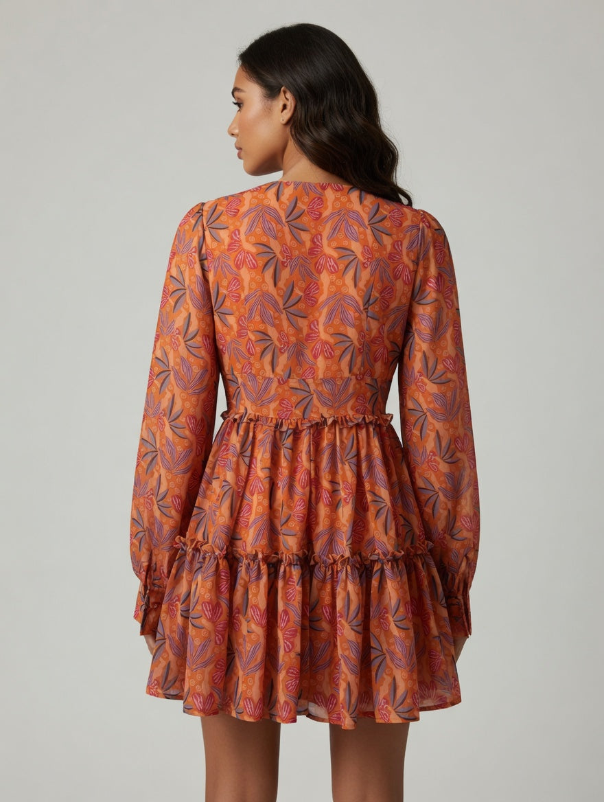 Woman wearing an orange floral dress on a gray background